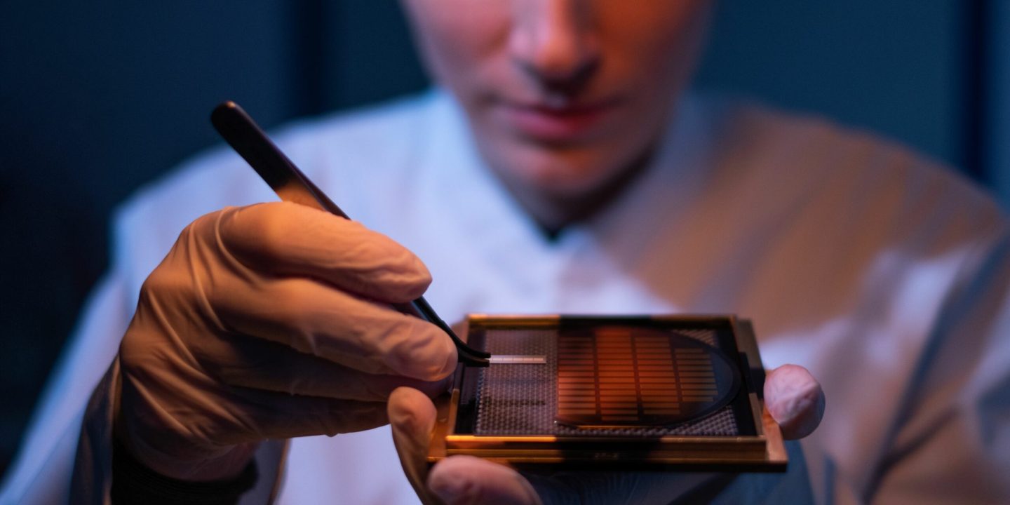 Q.ANT A Q.ANT employee inspecting a quantum chip Q.ANT A Q.ANT employee inspecting a quantum chip